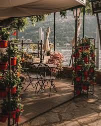 Terrazza con vista sul Lago di Como, fiori e tavoli all'aperto
