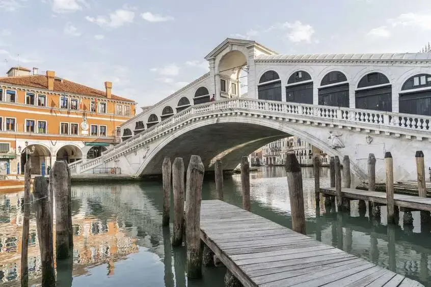 Venice day trip from Milan private tour - Rialto Bridge gondolas Grand Canal blue sky